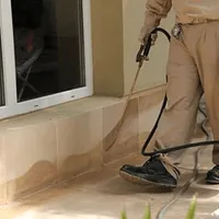 General pest control technician spraying exterior perimeter around a home in Orlando, FL